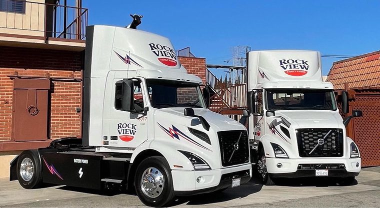 Two parked white heavy duty trucks with Rockview Trucks logos